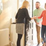 estate agent welcoming a couple to house viewing