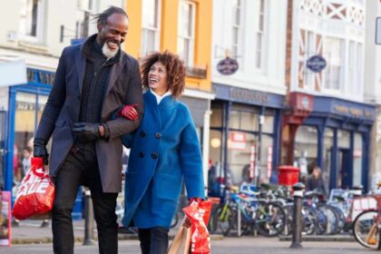 Mature black couple enjoying shopping together in UK high street