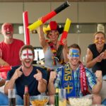 many happy international football fans watching tv